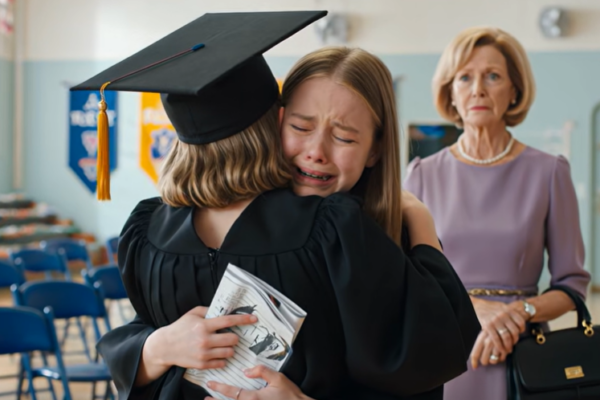 Tijdens de diploma-uitreiking van mijn dochter op de middelbare school kwam de moeder die ooit schreef: “Dat kind zal je leven verpesten”, de eerste rij binnenlopen, met lavendelkleurige parels om haar nek en zichzelf “oma” noemend. Ik streek de witte kraag van mijn dochter glad, nam plaats op de derde rij en keek toe hoe ze een crèmekleurige envelop naar het podium droeg alsof die veertien jaar op dat moment had gewacht.